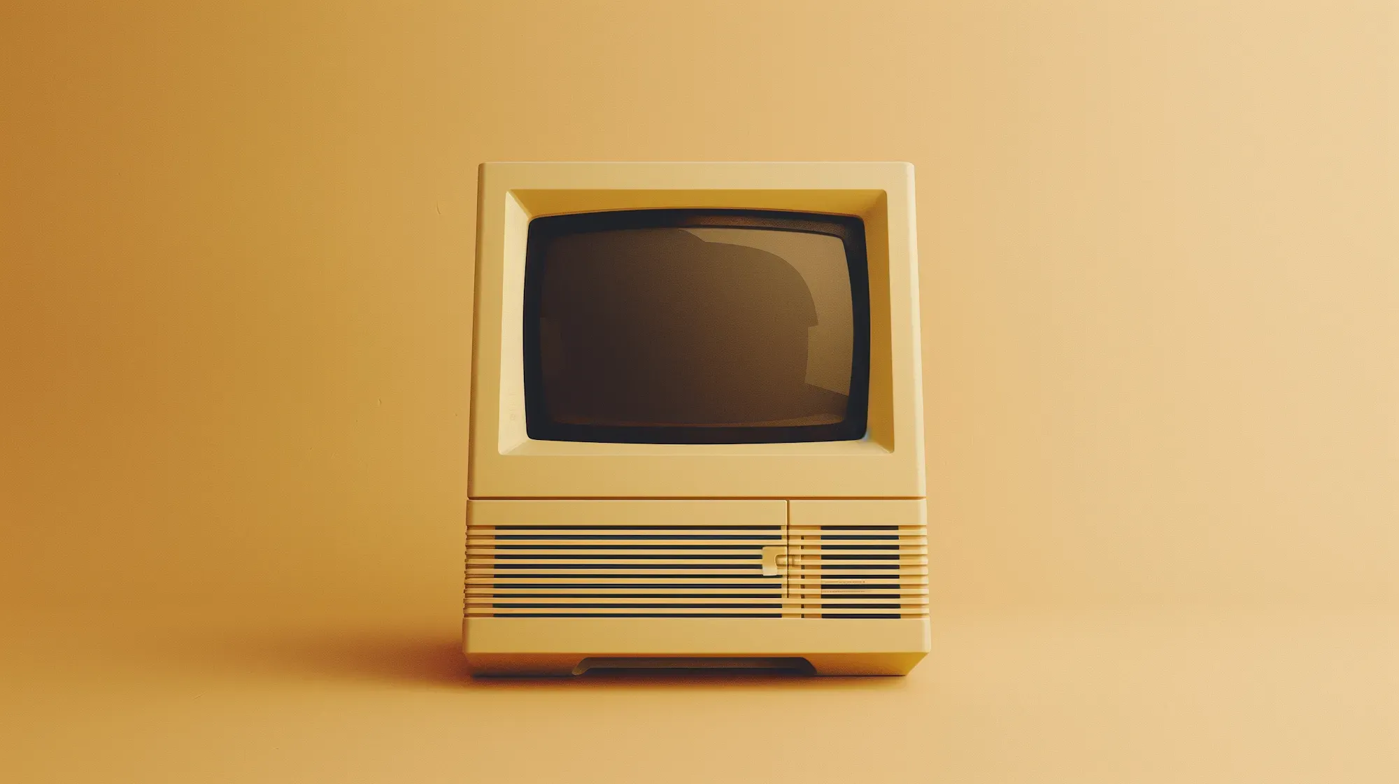 A beige vintage computer against a warm mustard backdrop
