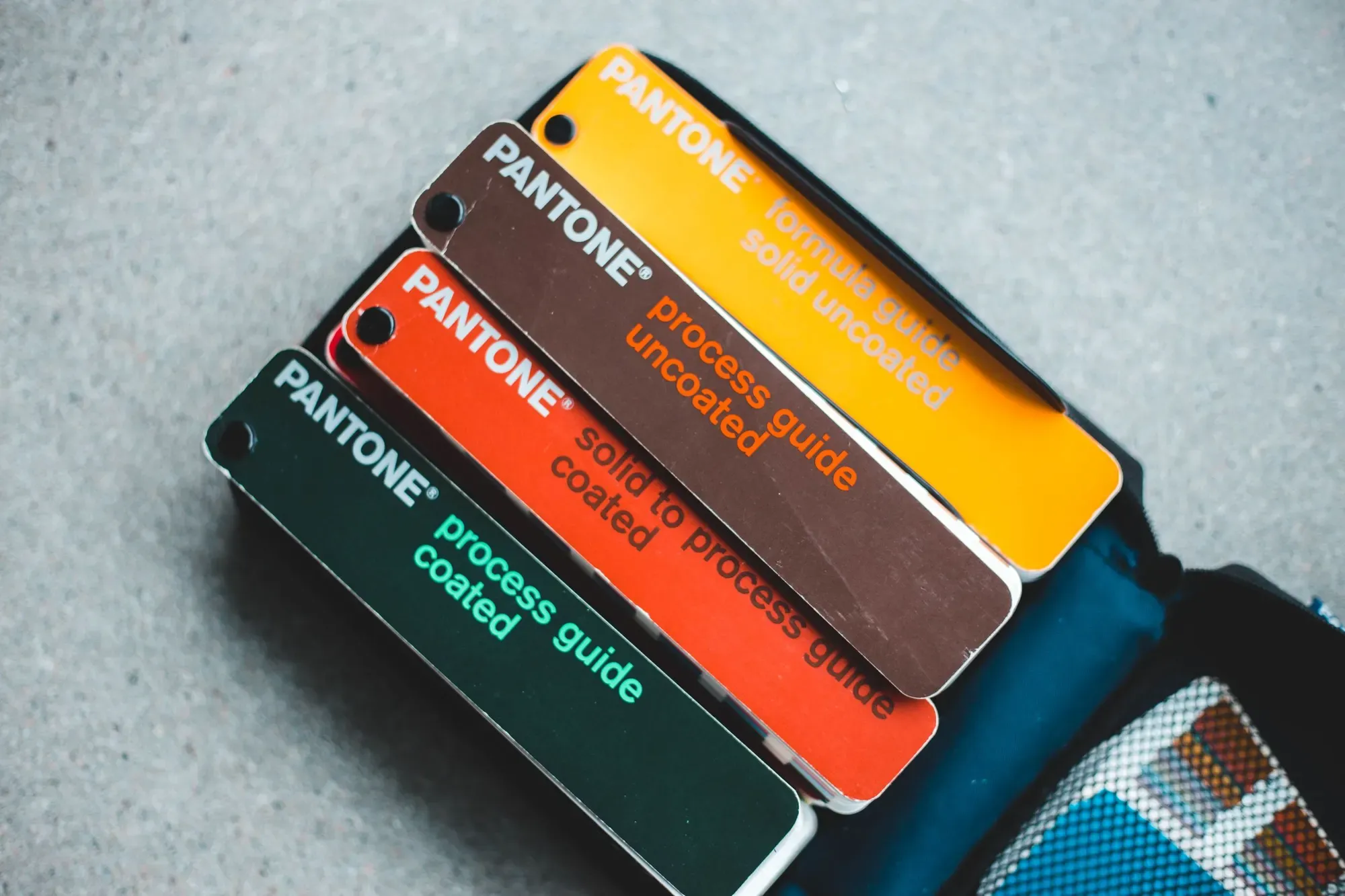 Pantone colour guides stacked on a grey surface