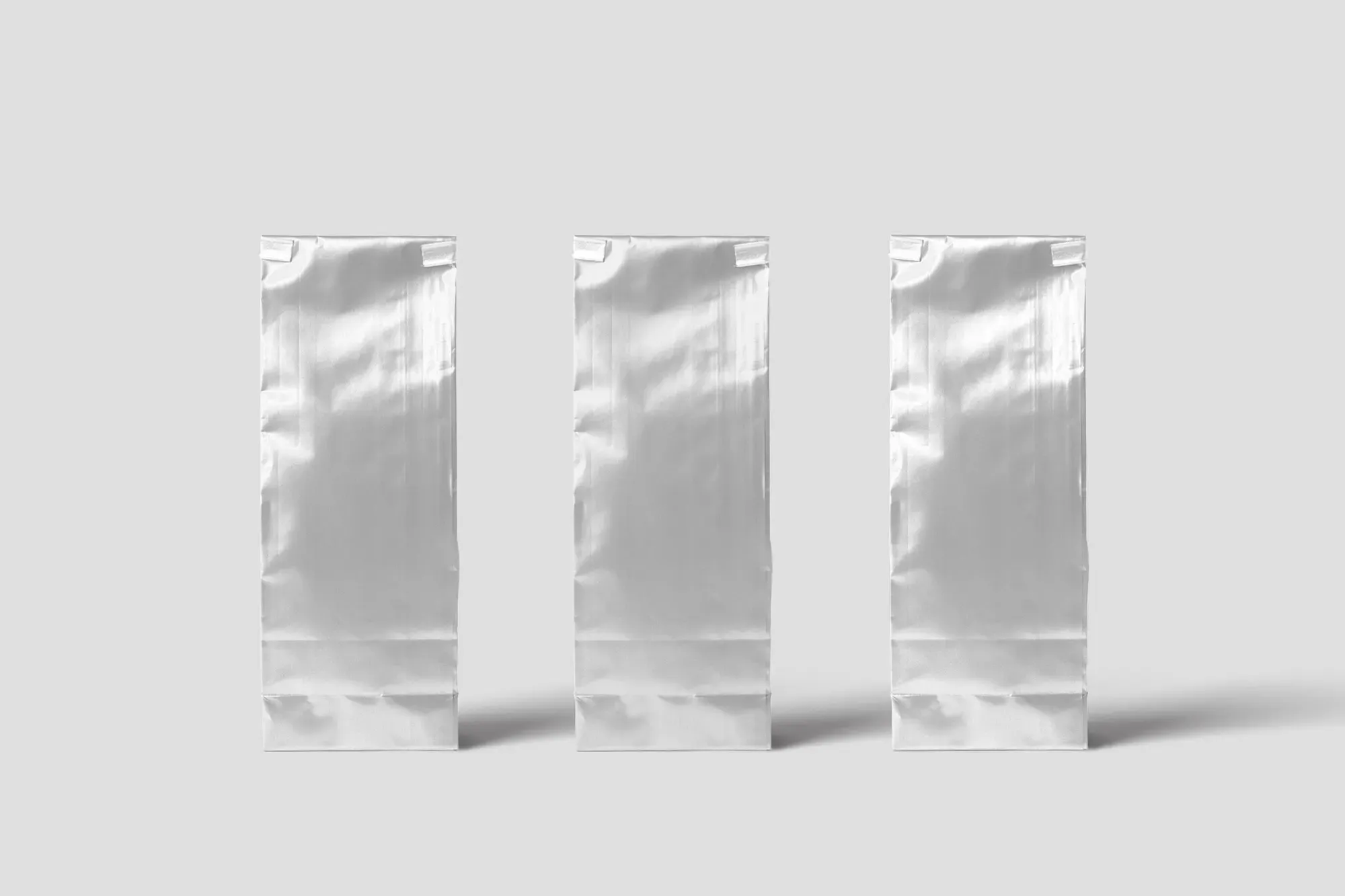 Three blank foil packaging pouches ready for a brand mark