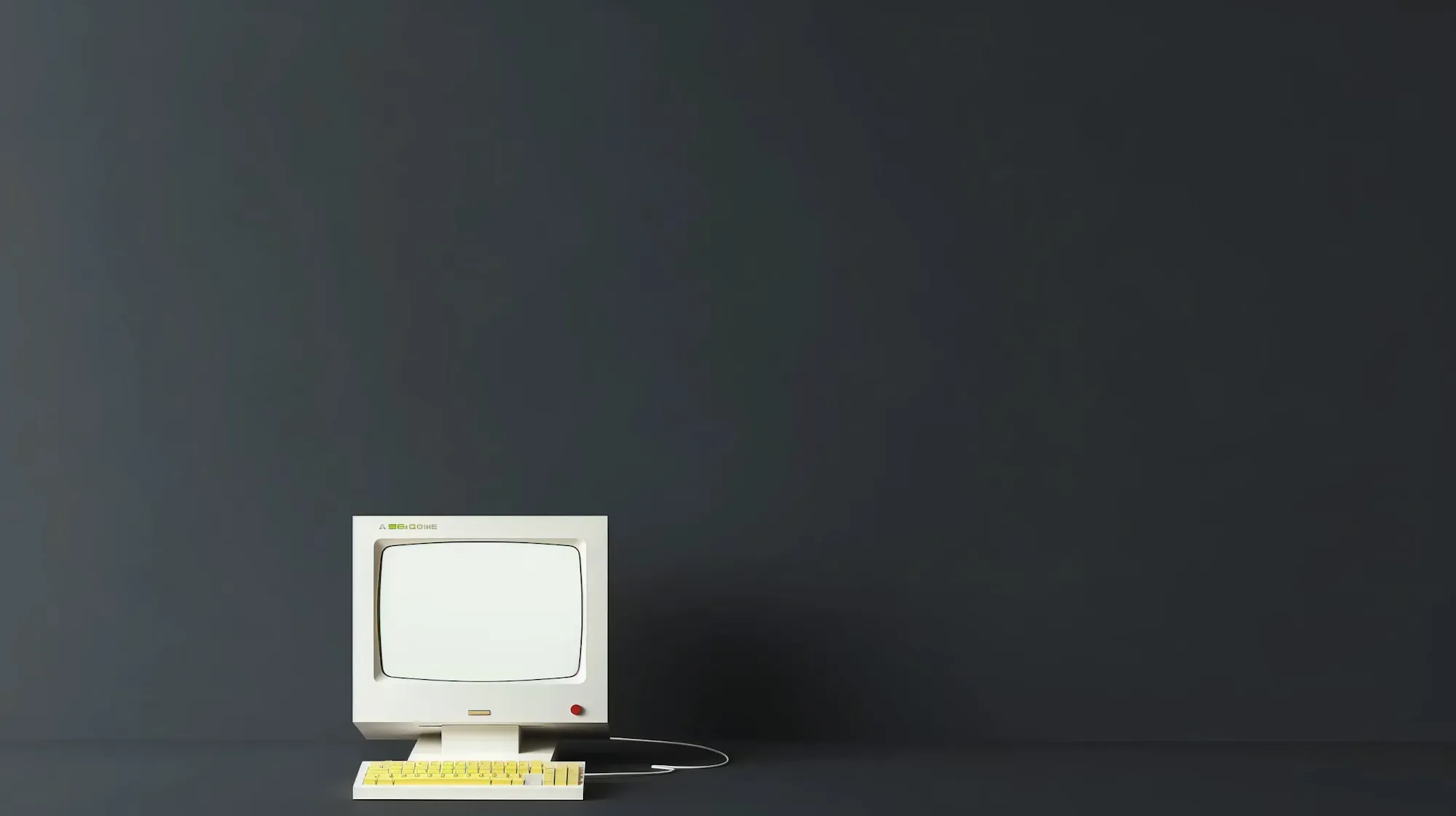 A small vintage computer alone in a dark, empty room