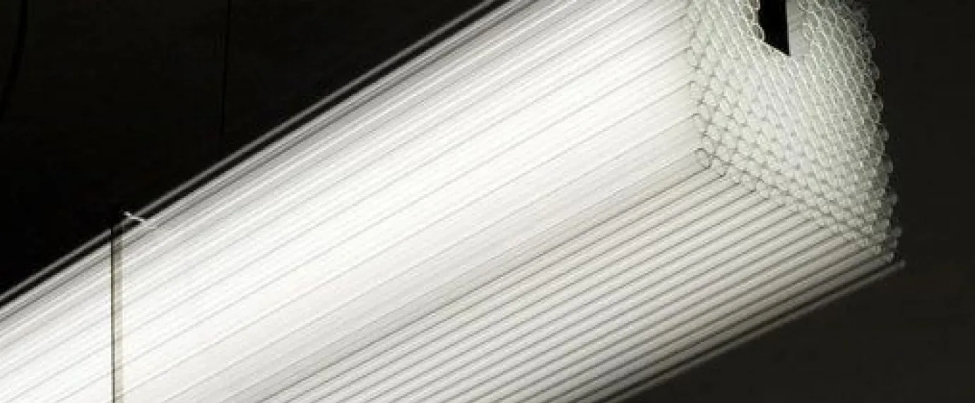 Bundle of translucent light tubes glowing against a black background