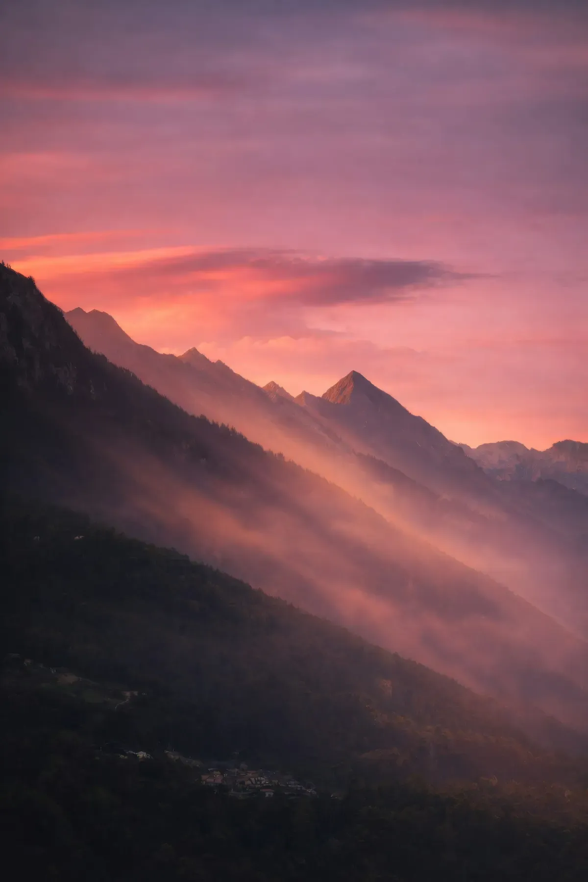 Mountain ridges fading into pink mist at sunset